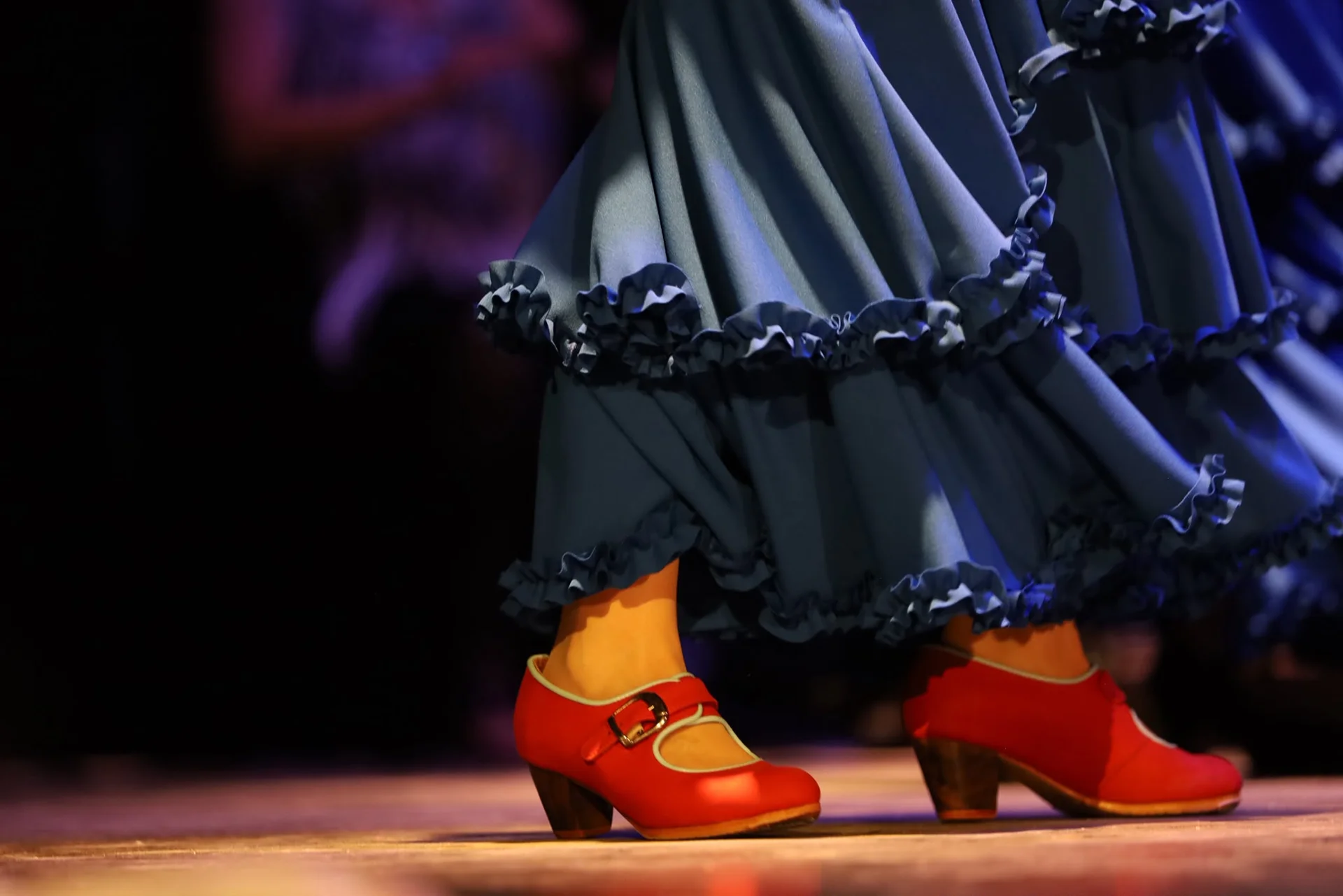 Detalle de zapatos rojos y faldas durante el baile