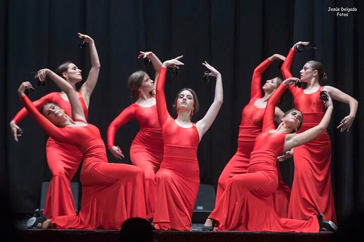 Grupo de baile con vestidos rojos en una coreografía flamenca