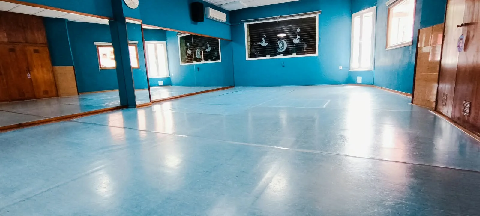 Sala de danza de la escuela con espejos, barras y suelo despejado